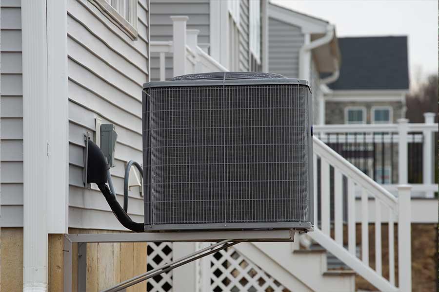 Replacement air conditioning unit securely mounted beside a residential property